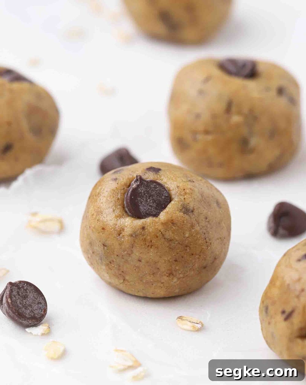 No-Bake Chocolate Chip Energy Bites 2 Cookie dough balls on a table.