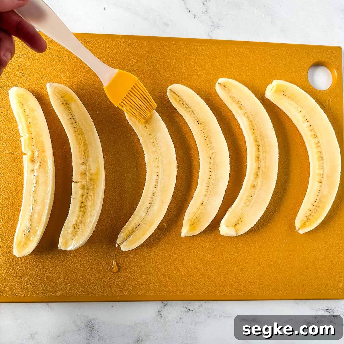 Halved bananas brushed with maple syrup.
