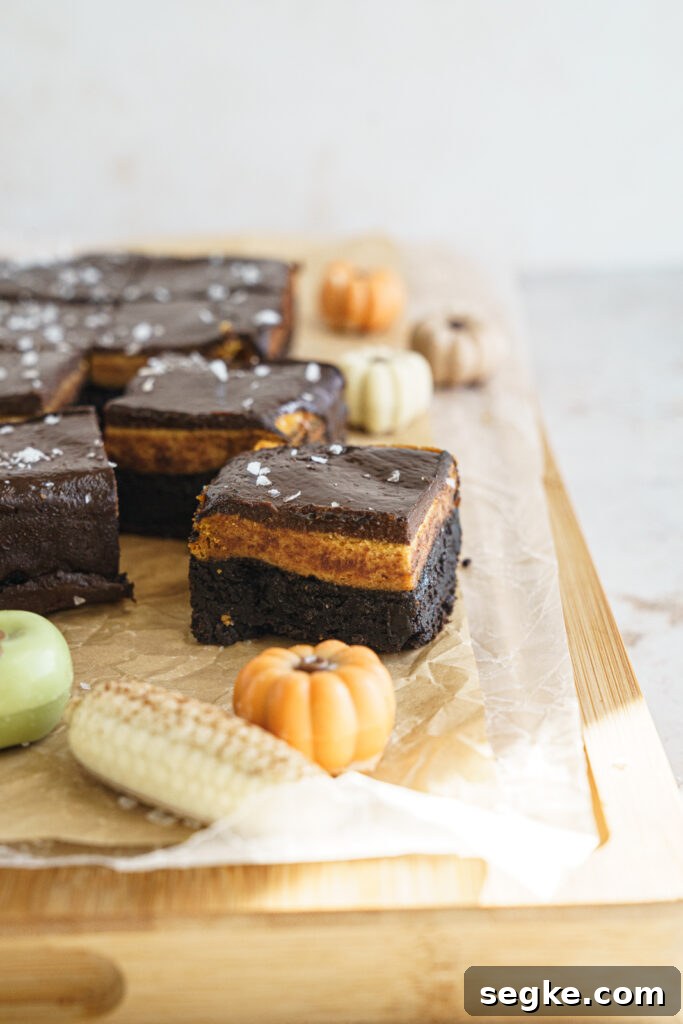 Pumpkin cheesecake layer spread over brownie batter