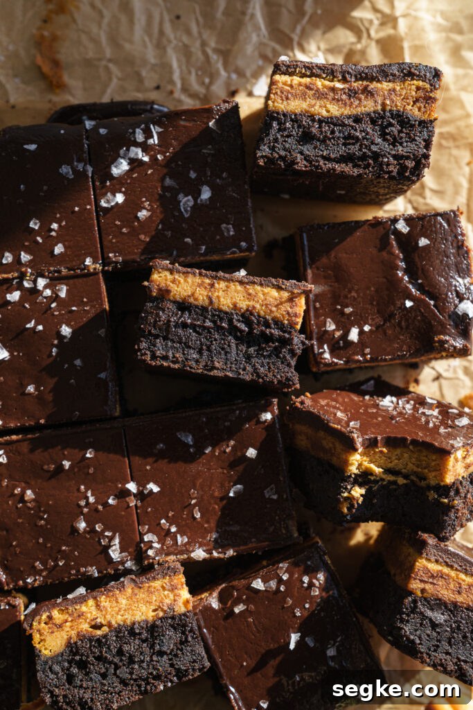Cut pumpkin cheesecake brownies on a board