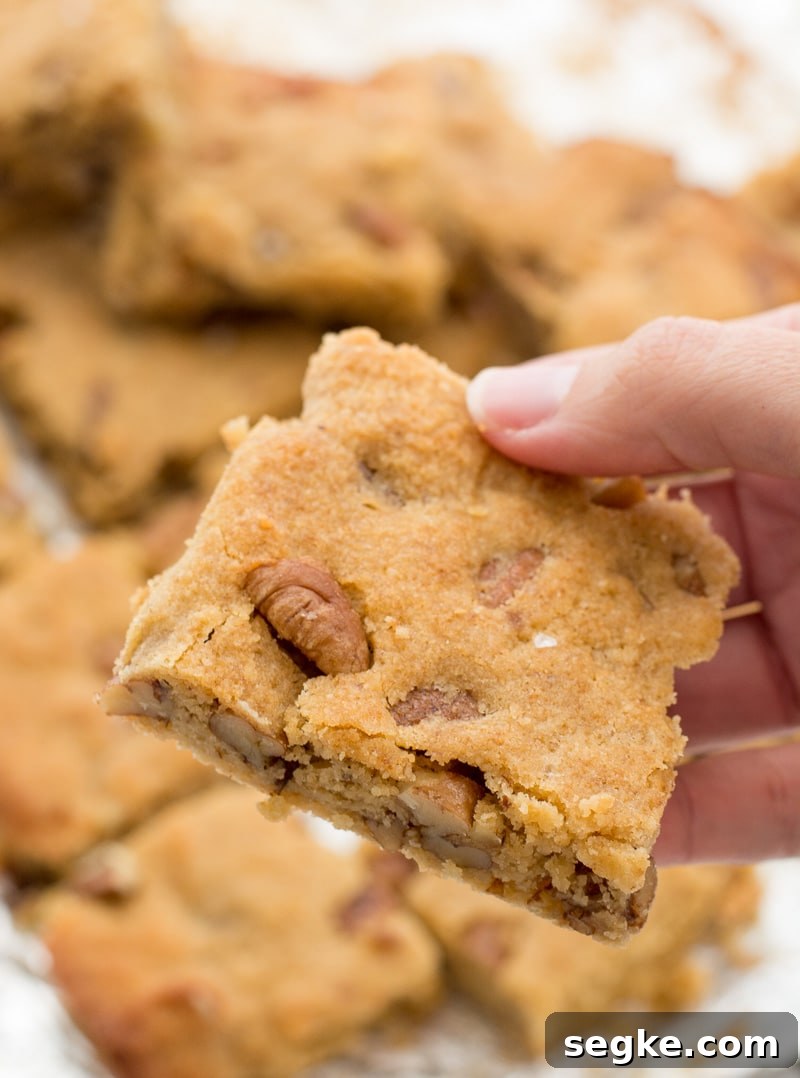 Keto Butter Pecan Blondies Recipe 2 An almond flour blondie being held aloft.