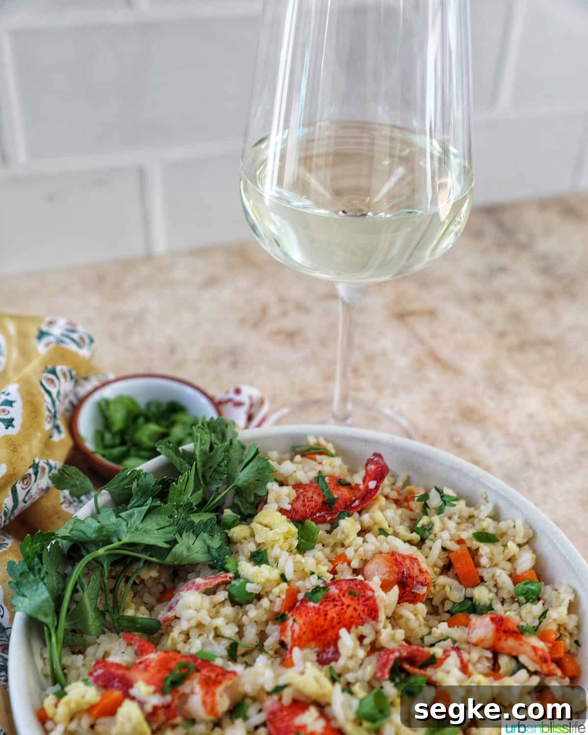 Garlic Butter Lobster Fried Rice 13 bowl of lobster fried rice with bowls of fresh herbs and a glass of white wine.