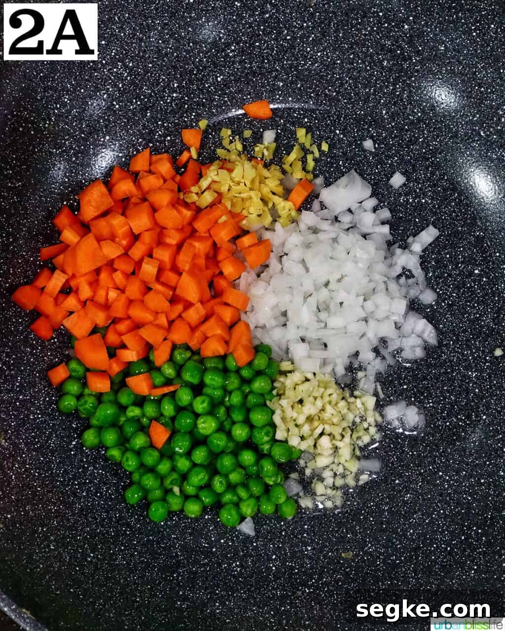 Garlic Butter Lobster Fried Rice 6 carrots, peas, onions, and garlic in a wok.