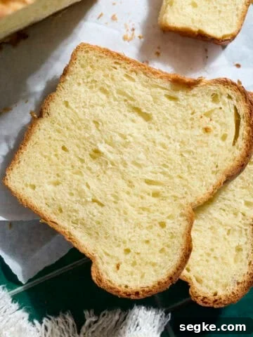 A slice of Sourdough Discard Brioche Bread on parchment paper.