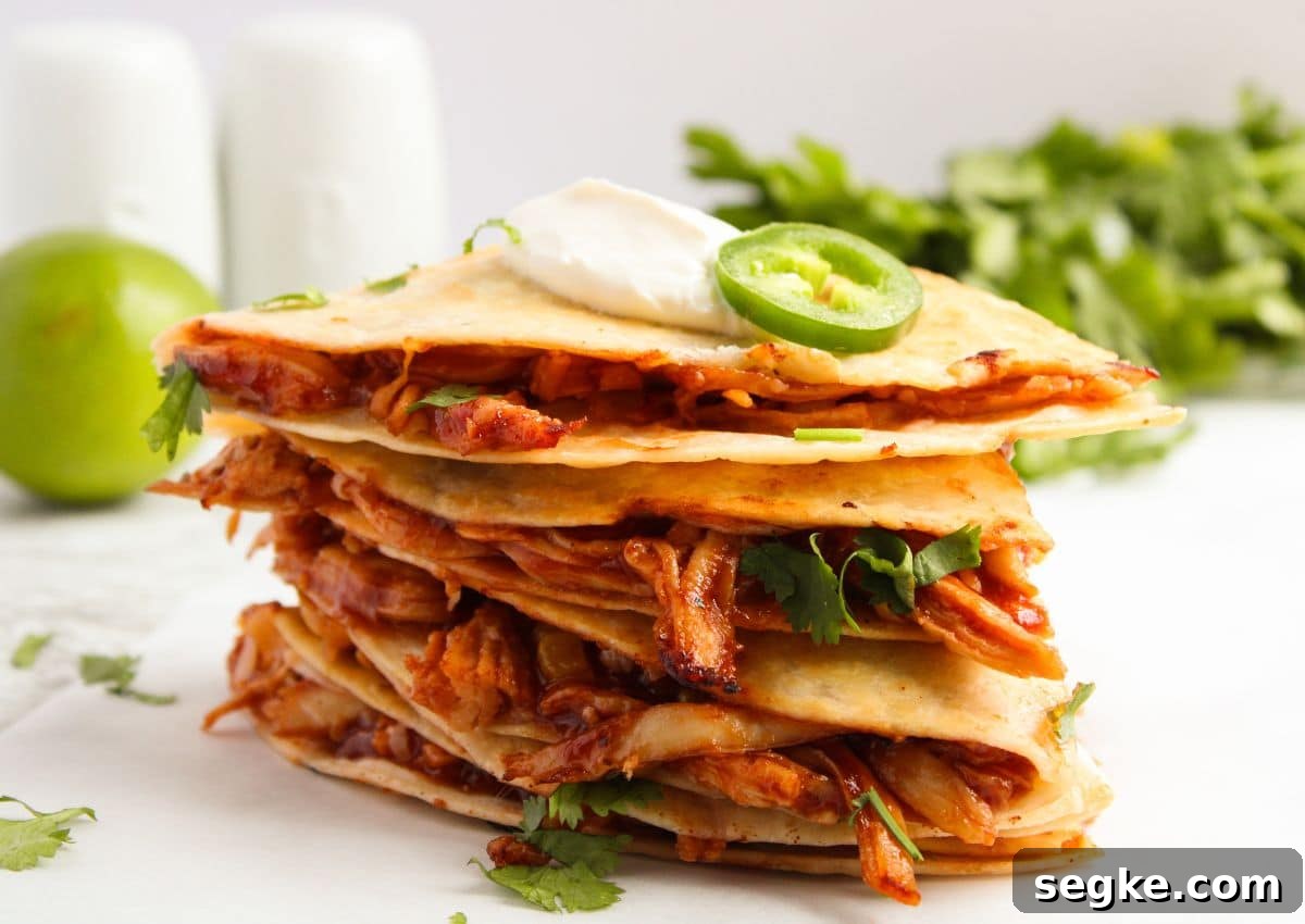 Smoky BBQ Chicken Quesadillas with Melted Cheese 11 BBQ chicken quesadilla pieces stacked on top of each other.