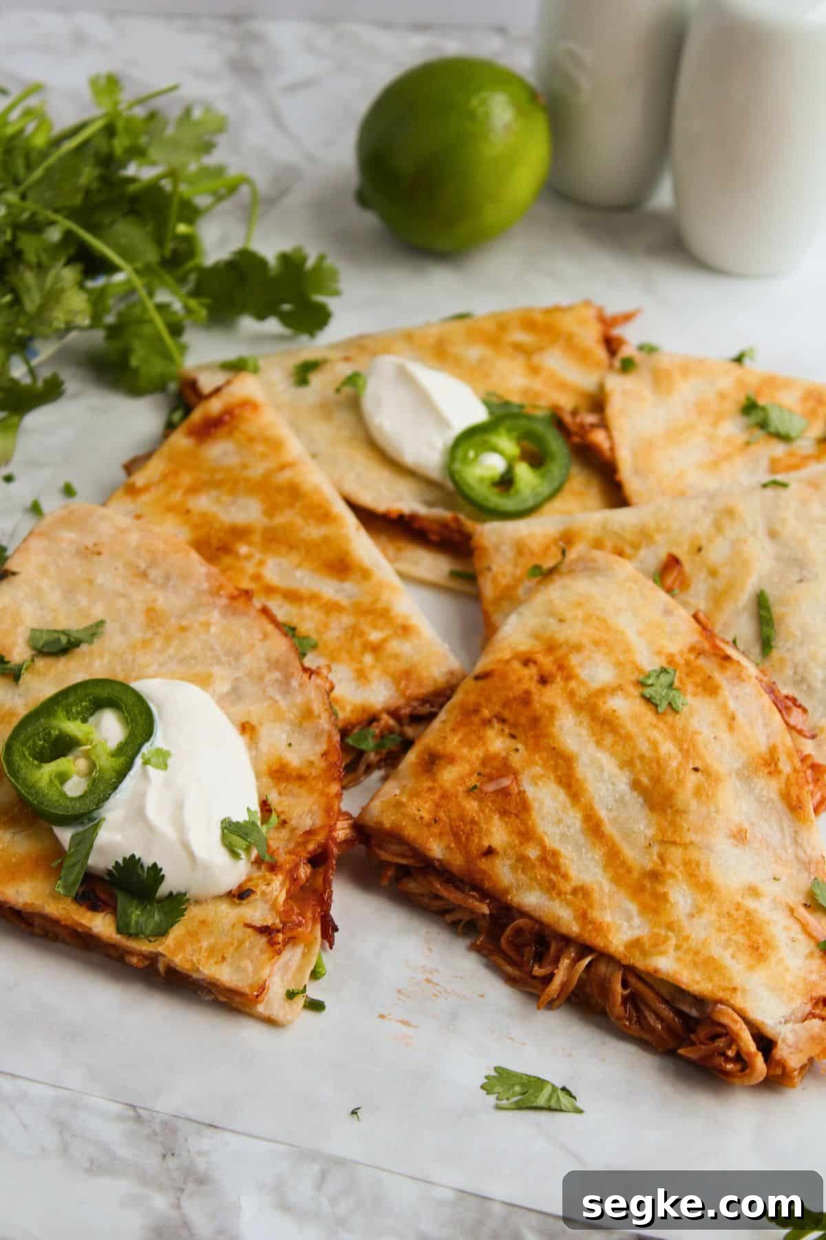Smoky BBQ Chicken Quesadillas with Melted Cheese 3 BBQ chicken quesadilla pieces on a counter.