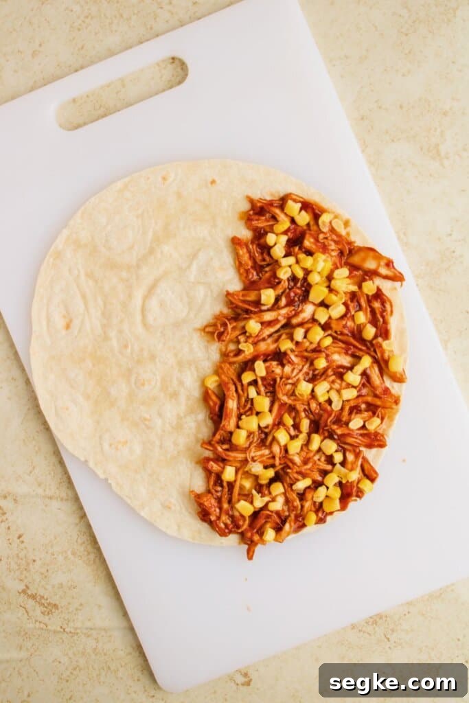 Smoky BBQ Chicken Quesadillas with Melted Cheese 7 Corn being added to the top of a tortilla.