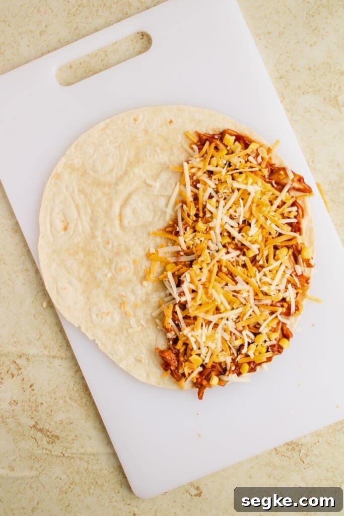 Smoky BBQ Chicken Quesadillas with Melted Cheese 8 Cheese being sprinkled on meat on a tortilla.