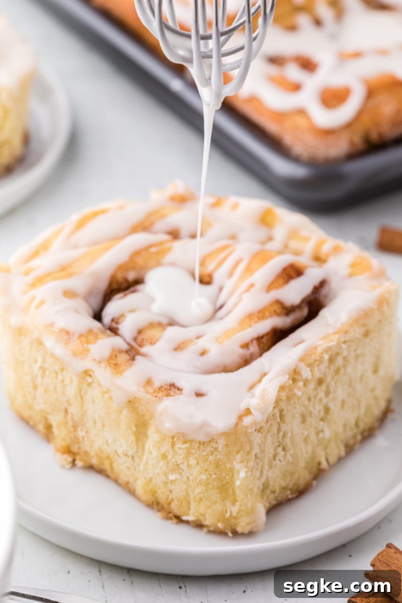 Pouring icing pouring icing onto a cinnamon roll