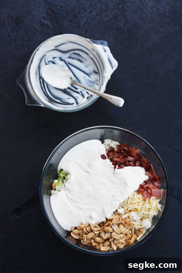 Overhead of all the ingredients together in a glass bowl for a broccoli and bacon and apple salad before being mixed up.