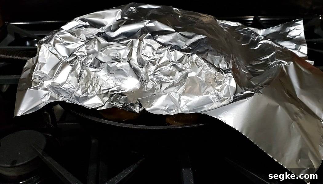 tin foil tent over cooked whole roast chicken.