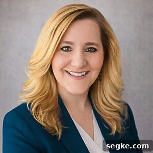 a professional portrait of zona house wearing a teal blazer.