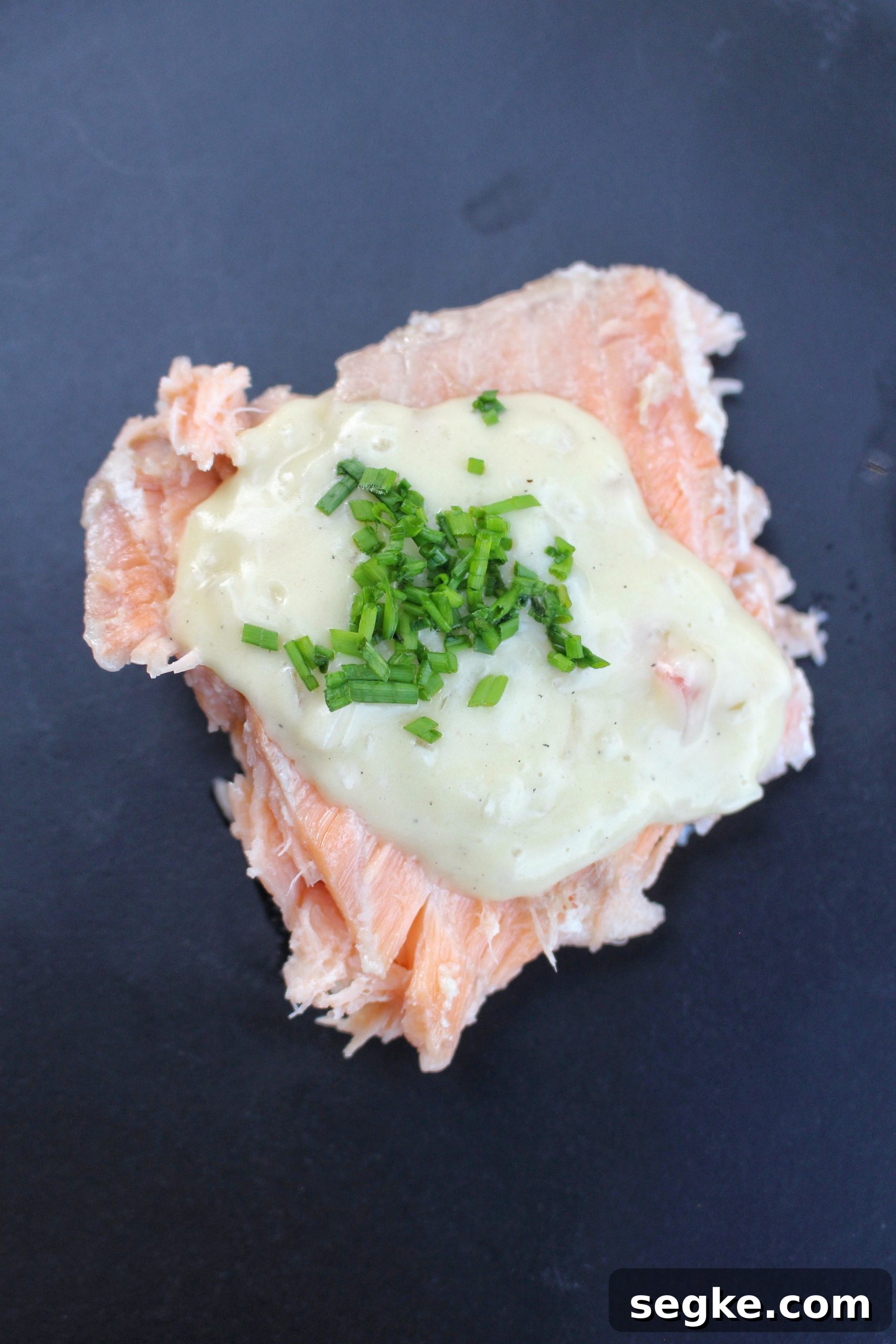 Salt-Crusted Salmon Recipe: Oven-Baked and Tender 7 Salmon topped with sauce and chives.