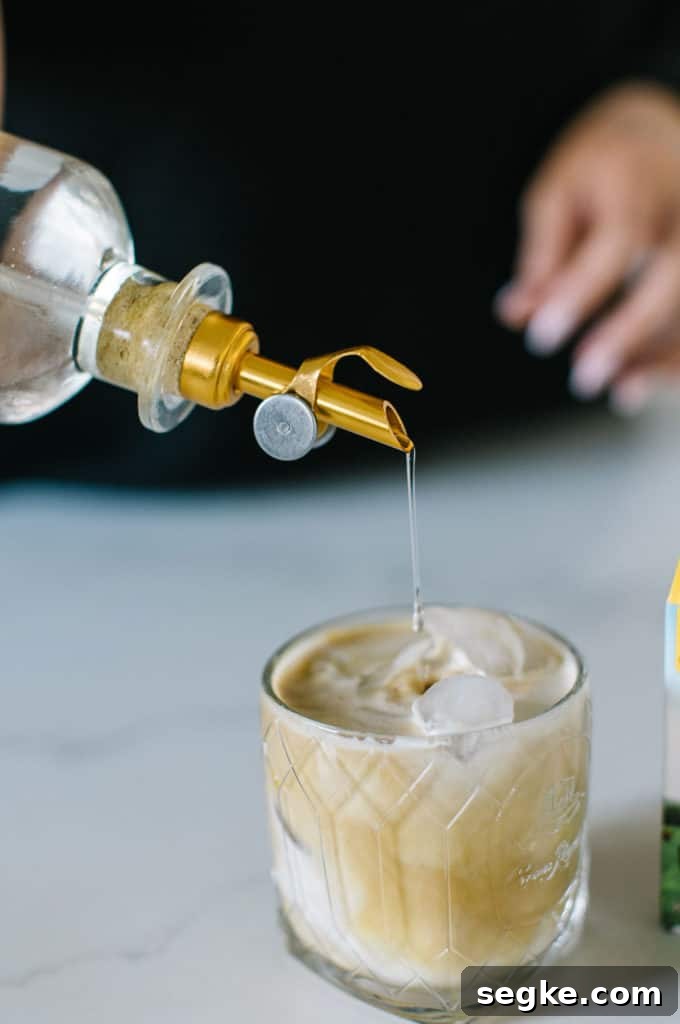 White Russian Mocktail with simple syrup being poured