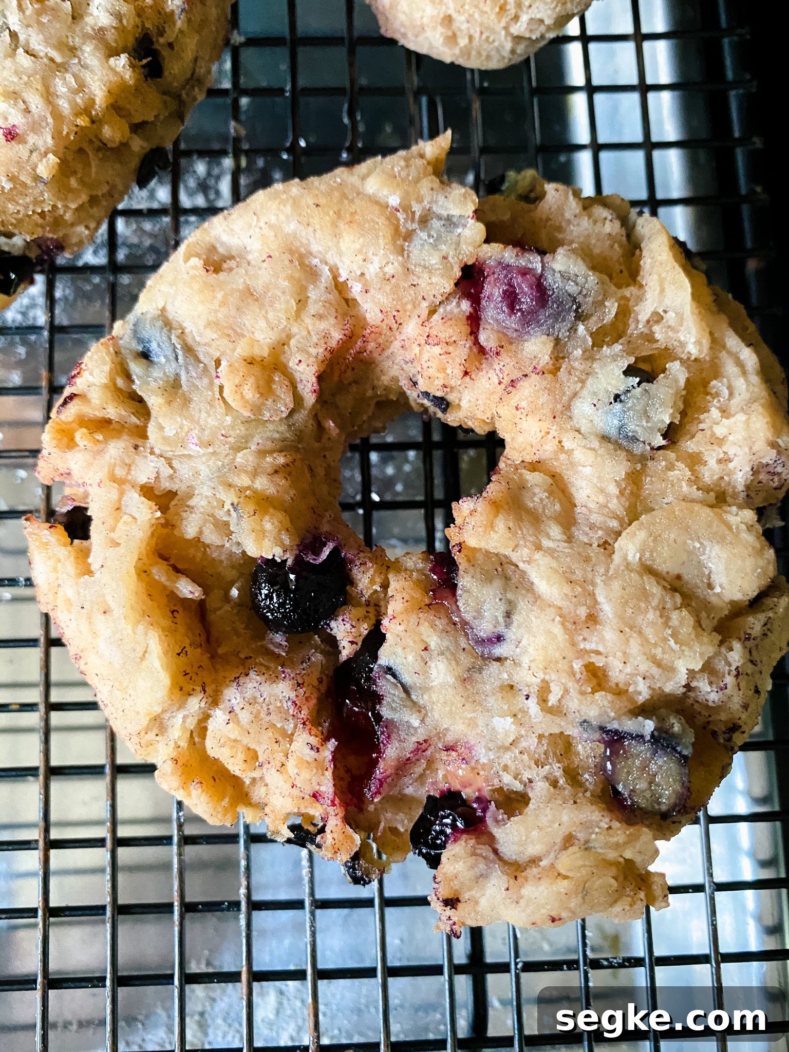 How to Make Homemade Fried Glazed Blueberry Donuts 11 Top down view of a freshly fried donut filled with blueberries.