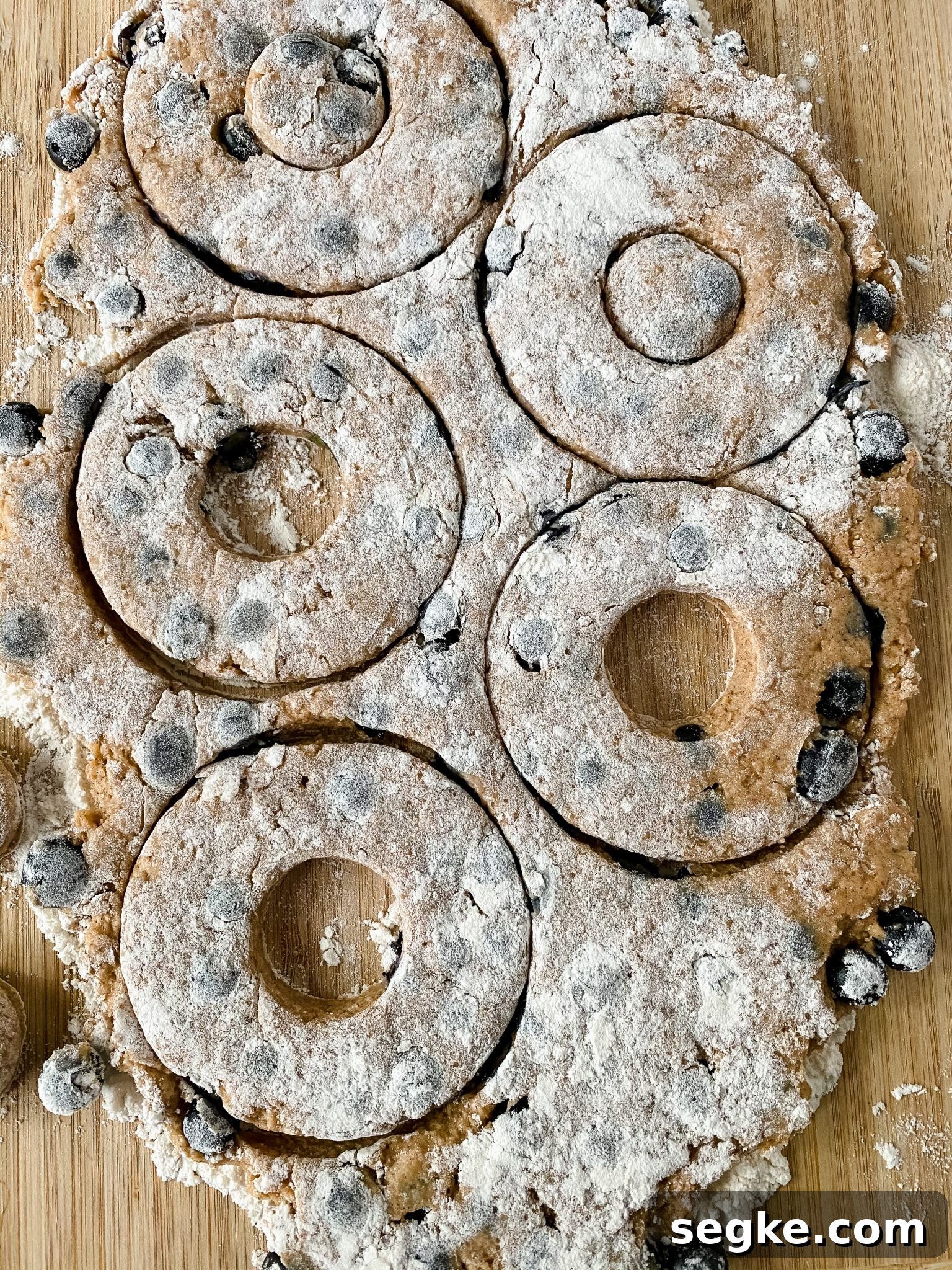 How to Make Homemade Fried Glazed Blueberry Donuts 9 Donut shapes stamped out of dough.