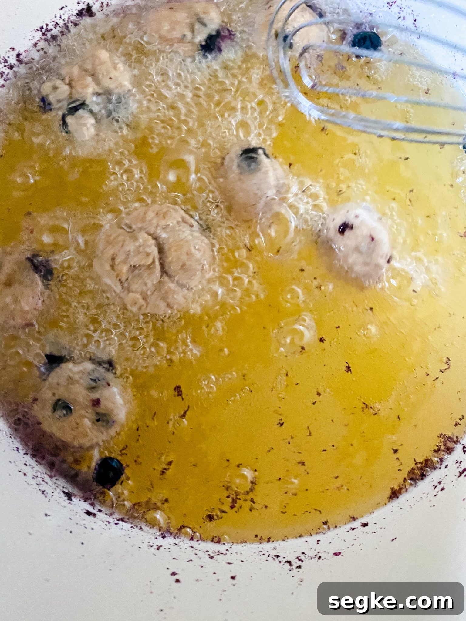 How to Make Homemade Fried Glazed Blueberry Donuts 10 Pan of boiling oil with donut batter dropped in to test it's heat level.