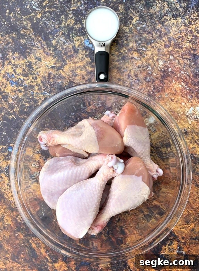 Crispy Panko Air Fryer Chicken Drumsticks 2 buttermilk and raw chicken drumsticks in a glass bowl