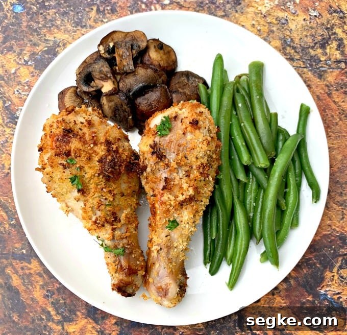 Crispy Panko Air Fryer Chicken Drumsticks 7 air fryer chicken drumsticks with green beans and mushrooms on a white plate