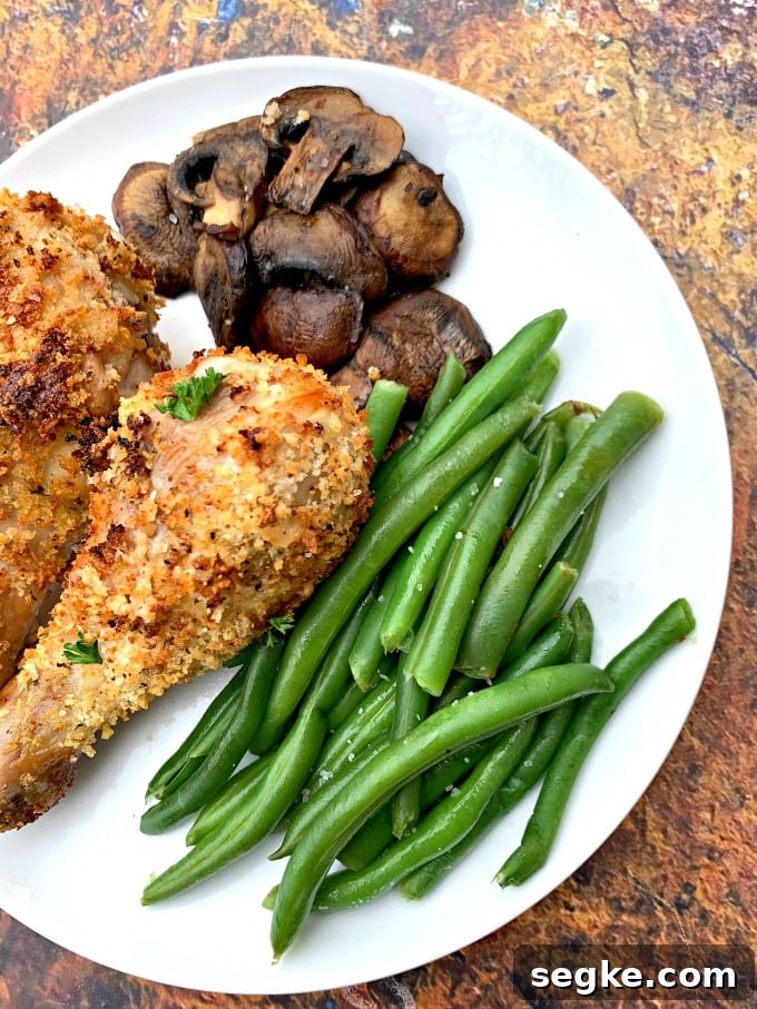 Crispy Panko Air Fryer Chicken Drumsticks 8 air fryer chicken drumsticks with green beans and mushrooms on a white plate