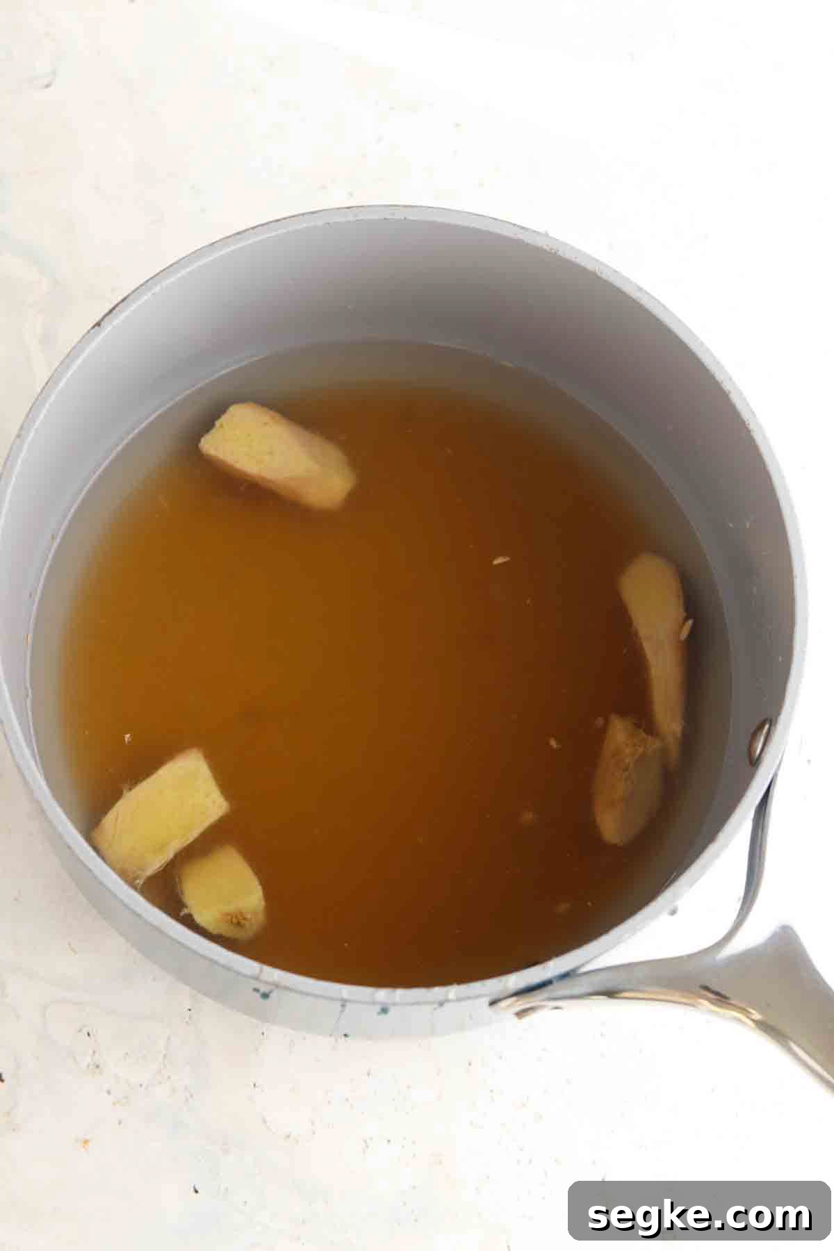 Ginger, water, honey and lemon in a sauce-pot.