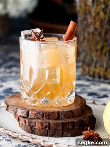 Clear glass with a brown drink and a cinnamon stick in it.