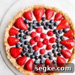 A fruit tart on a marble platter.