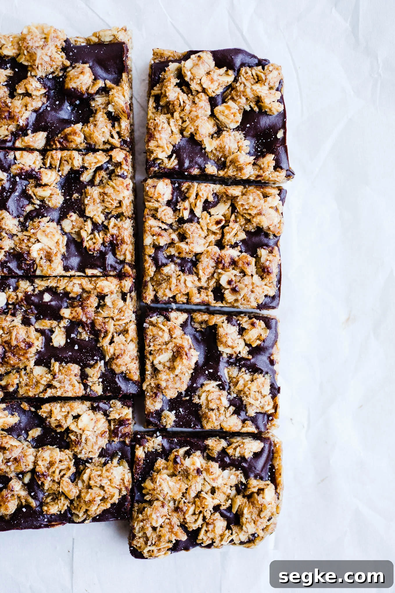 Almond Butter Oat Bars cut into squares on parchment paper.