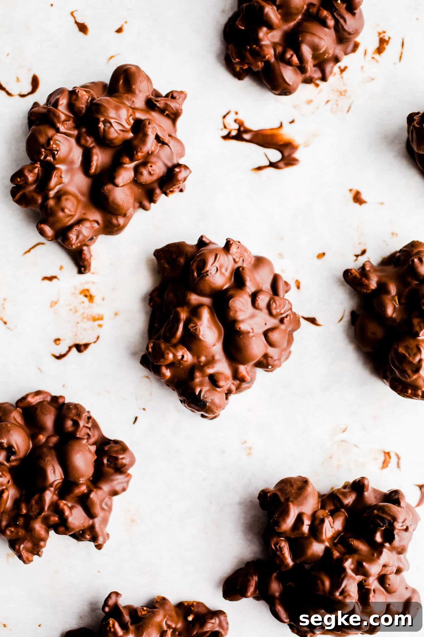 Chocolate blueberry clusters on parchment paper.