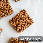 Chocolate squares made with rice cereal on parchment paper.