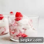 Whipped cream and raspberries in a glass.