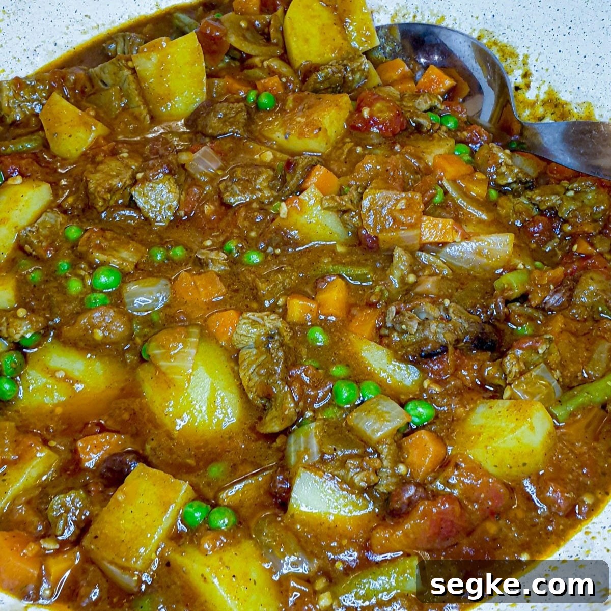 A close-up of a dish of leftover lamb curry, showing the meat and vegetables in the thick gravy.