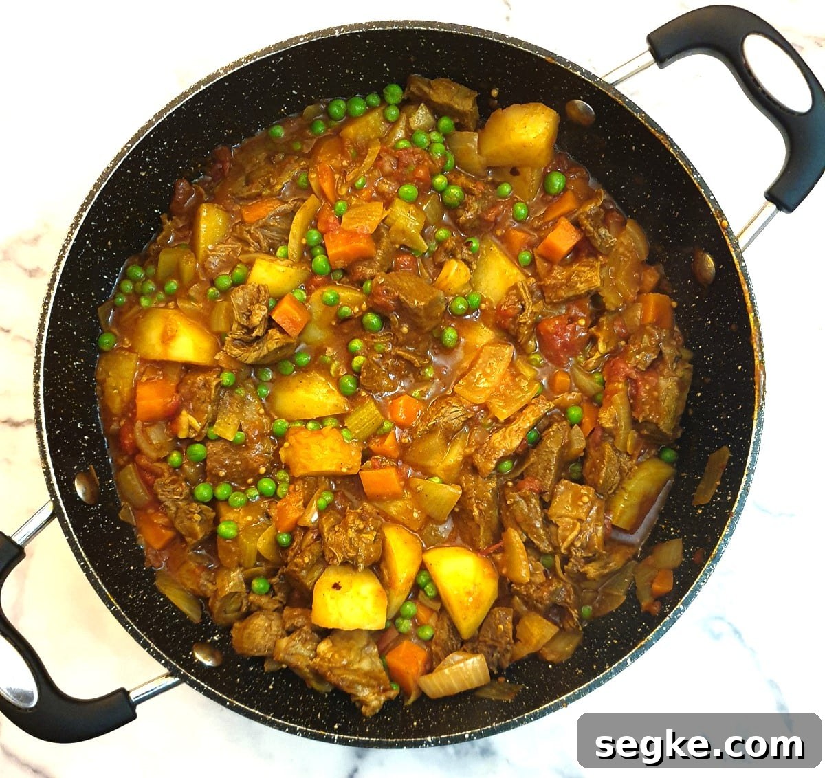 A finished dish of leftover lamb curry with the addition of frozen peas.