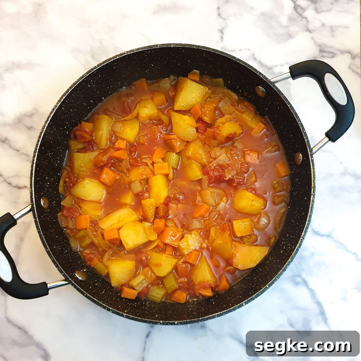 Cooked potatoes and tomatoes with curry sauce ready for the lamb to be added.