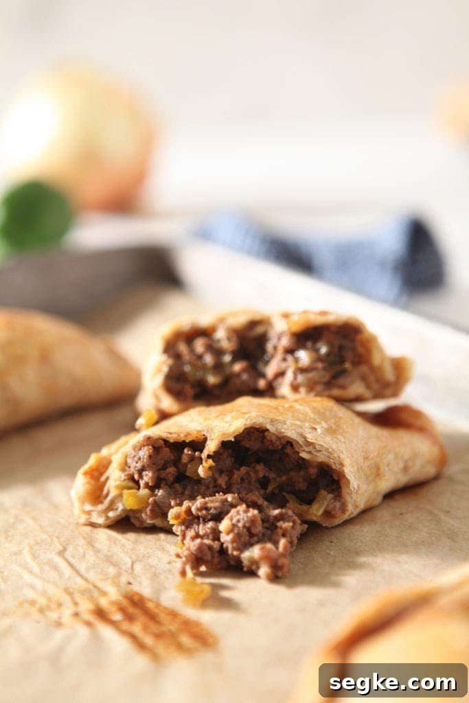 A halved meat pie is shown on a baking sheet, with ingredients in the background