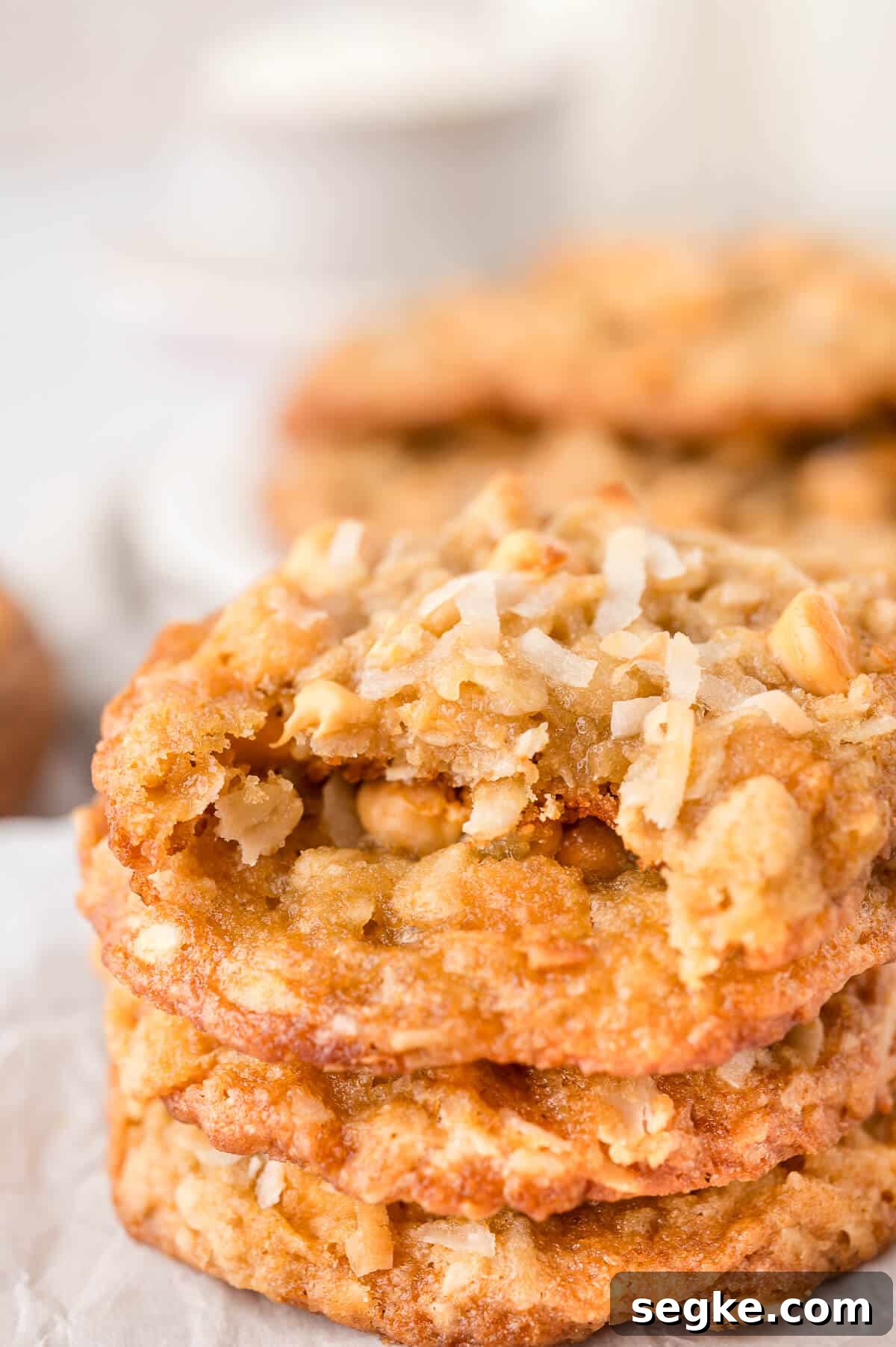 Chewy Coconut Butterscotch Cookie Recipe 8 A stack of coconut butterscotch cookies with a bite out of the top cookie.