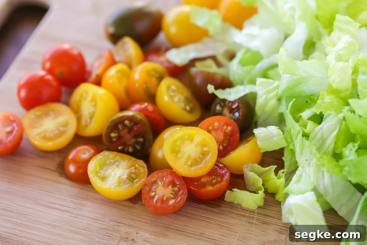 Walking Tacos: Portable Taco Cups for Parties and Tailgates 5 Sliced cherry tomatoes and shredded lettuce on a cutting board.