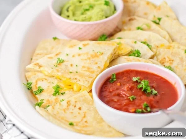 Walking Tacos: Portable Taco Cups for Parties and Tailgates 7 A cheese quesadilla sliced into triangles and served with cups of red and green salsa.