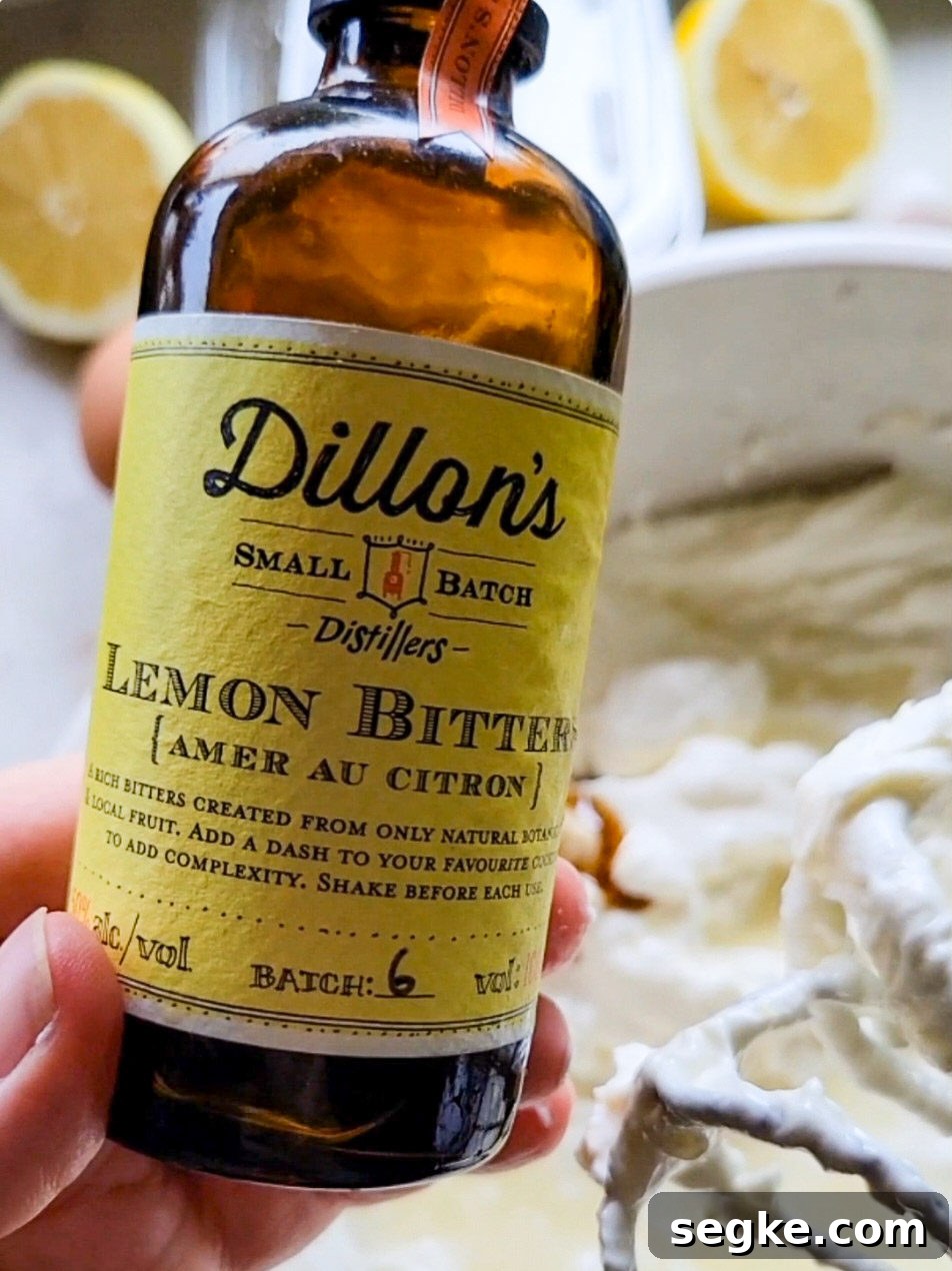 a bottle of lemon bitters with lemon cheesecake batter in a bowl in the background.