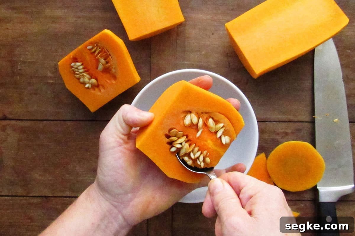 Scooping out seeds of butternut squash