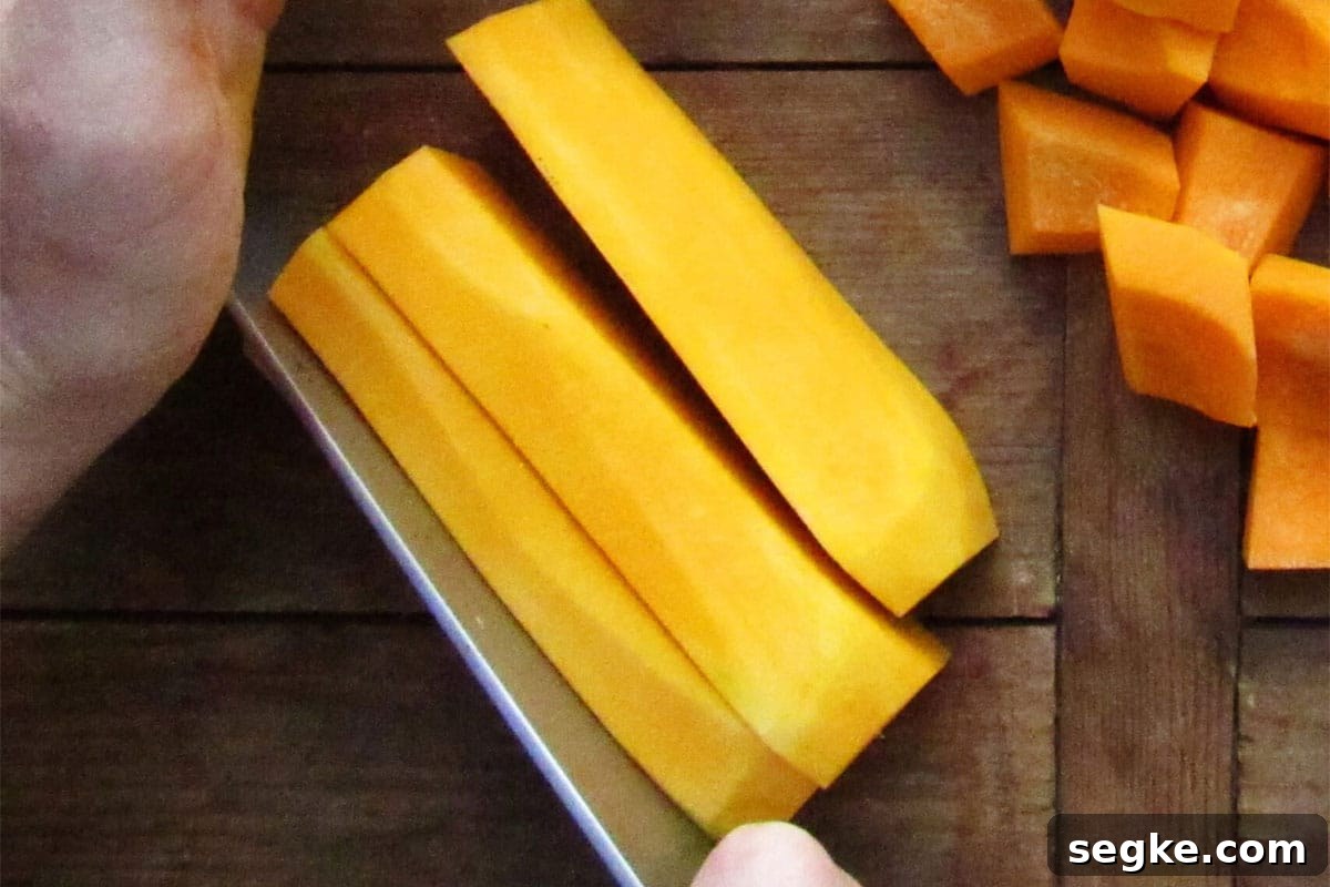 Cubing butternut squash on cutting board.