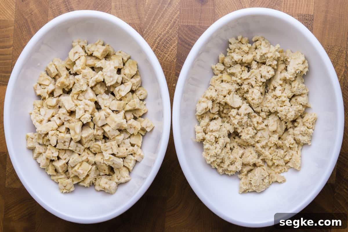 two white bowls of tempeh on a wooden background - one with tempeh minced in the food processor and one with tempeh cut small by hand.