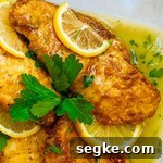 lemon chicken topped with a slice of lemon.
