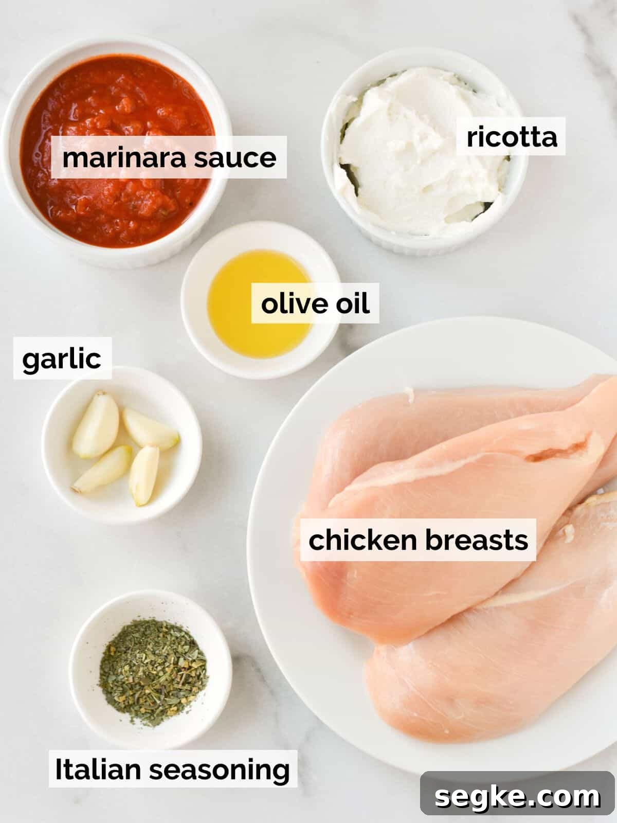 Ingredients for ricotta chicken on a white background.