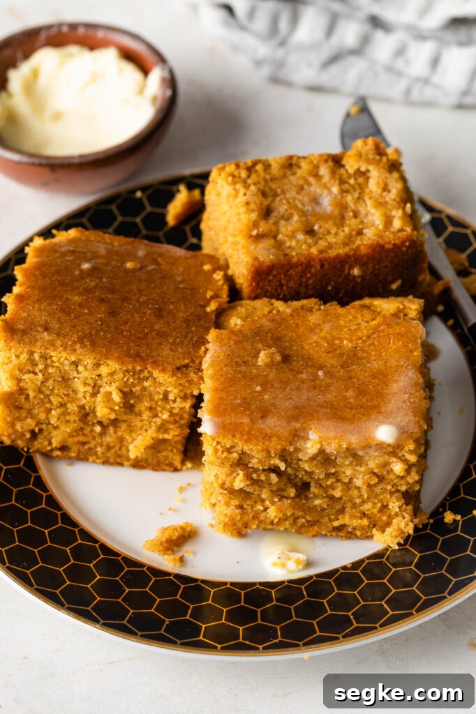 three pieces of sweet potato cornbread with melted butter on a plate
