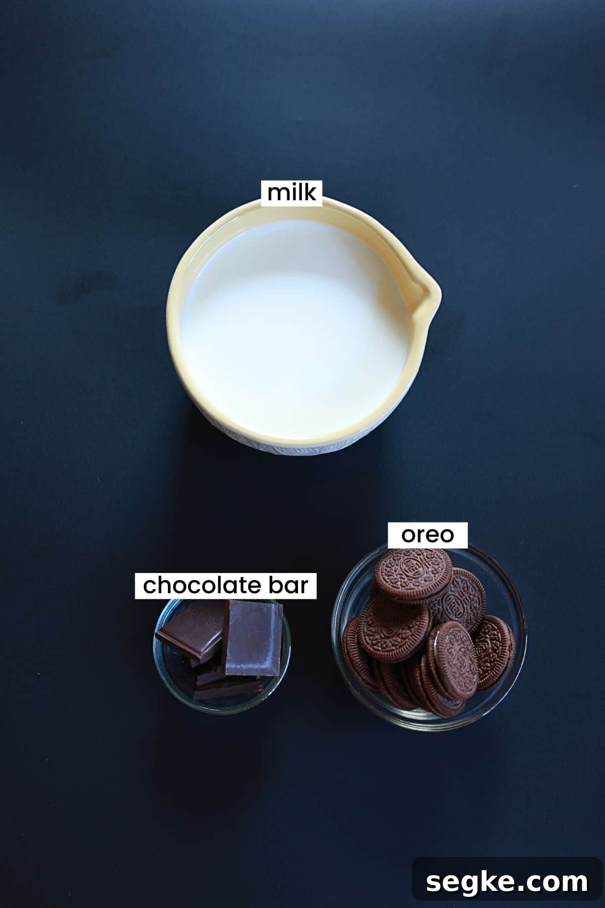 Oreo hot chocolate ingredients are placed on a dark background.