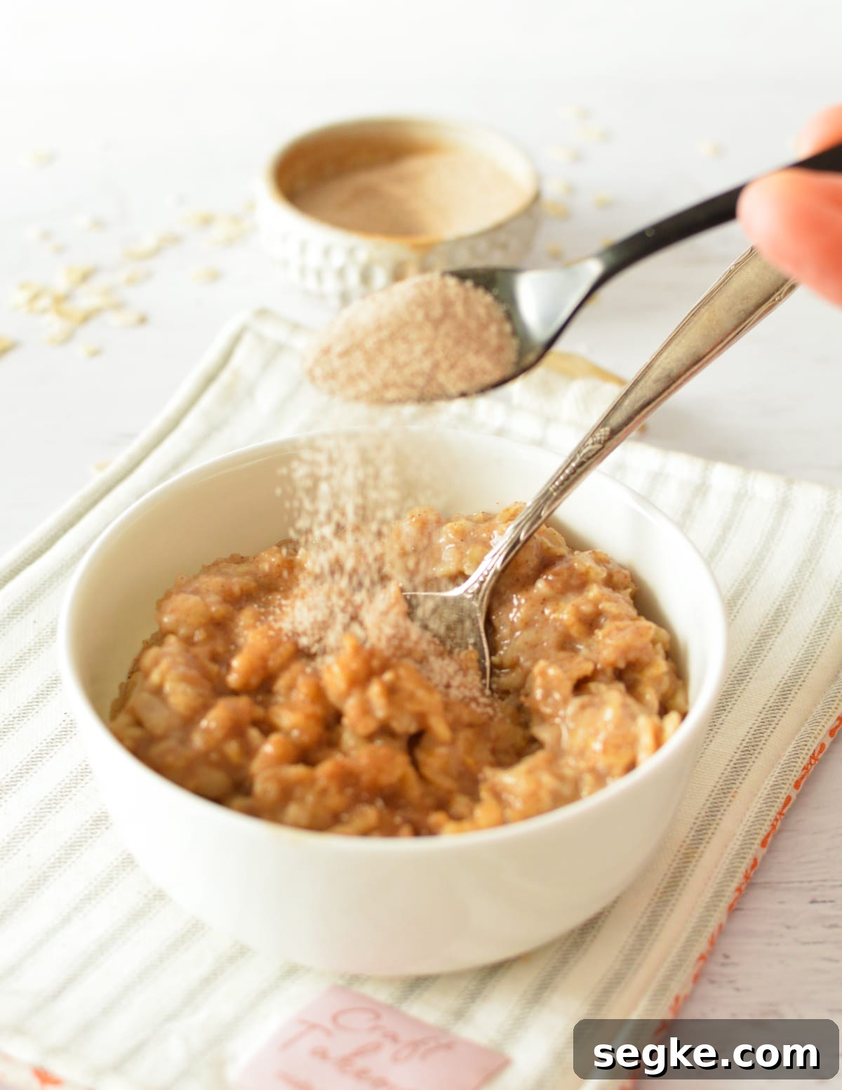 sprinkling cinnamon sugar on oatmeal.