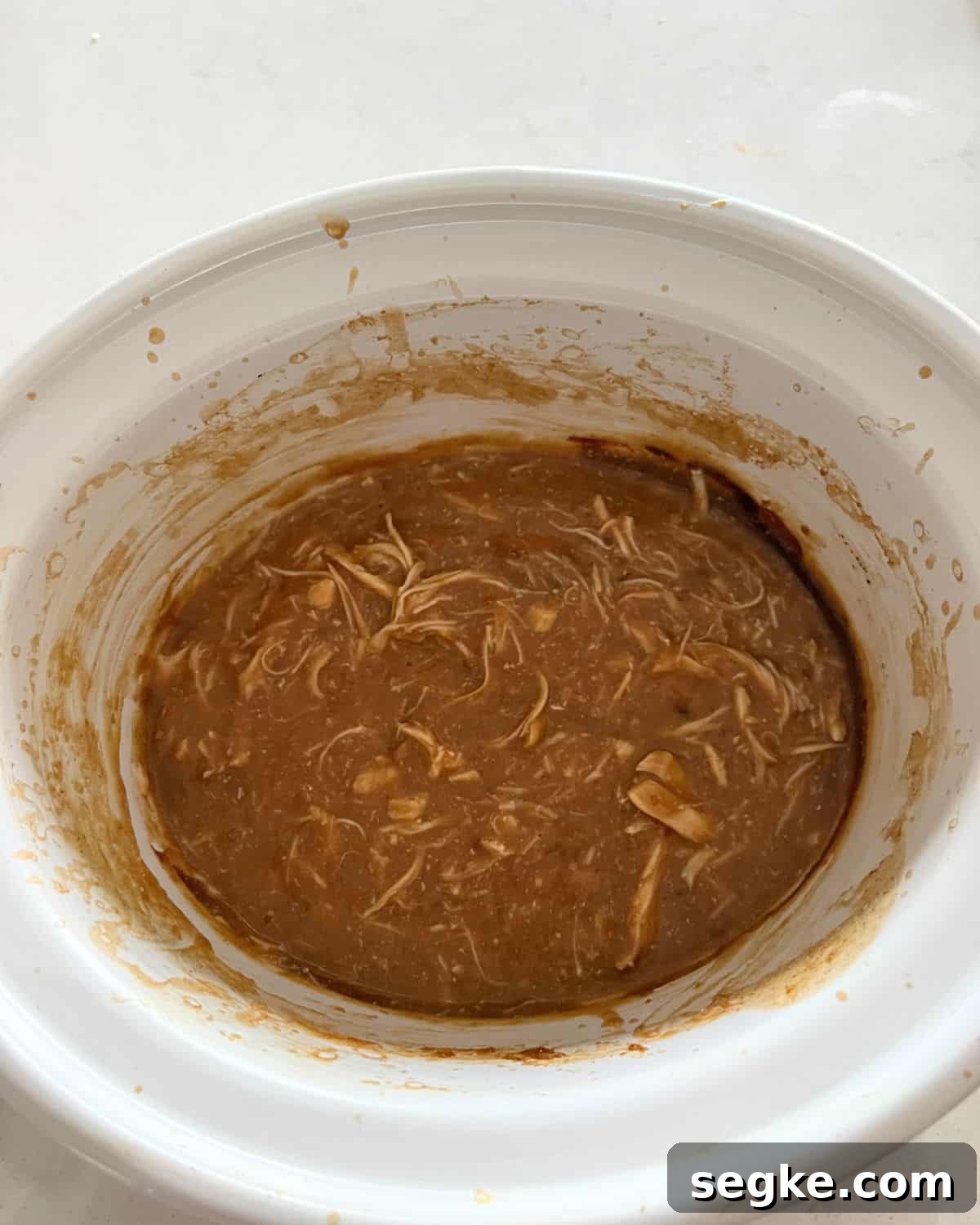 Shredded chicken with gravy in crock pot.