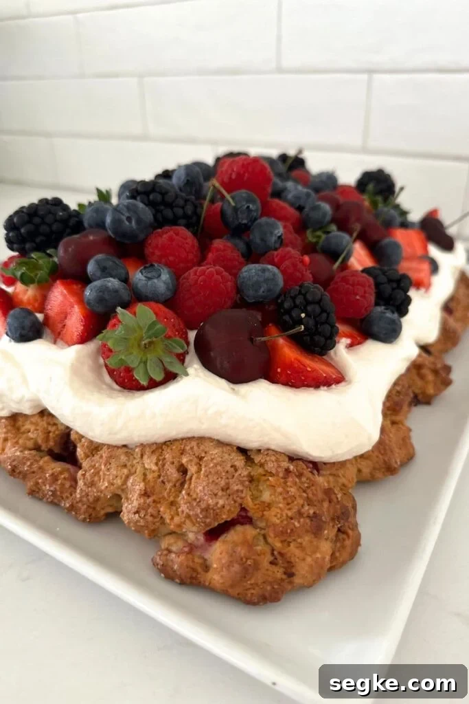 Sourdough berry sheet pan shortcake topped with whipped cream and berries.