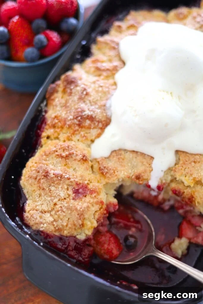 Single serving of sourdough berry cobbler topped with vanilla ice cream.